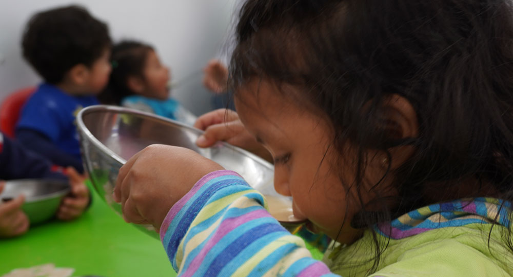 Niña tomando sopa en Centro de Desarrollo Infantil