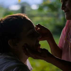 Kichwa woman painting volunteer's face for a ritual.