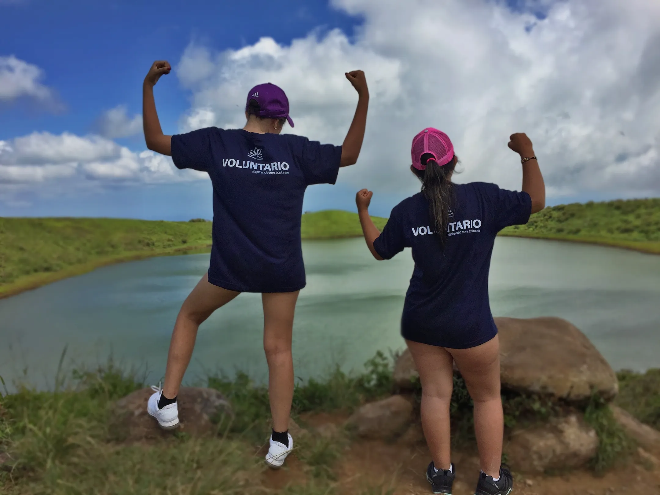Two participants of the TEEN Camp in Galapagos, in front of a lagoon posing after the beach cleanup activity.