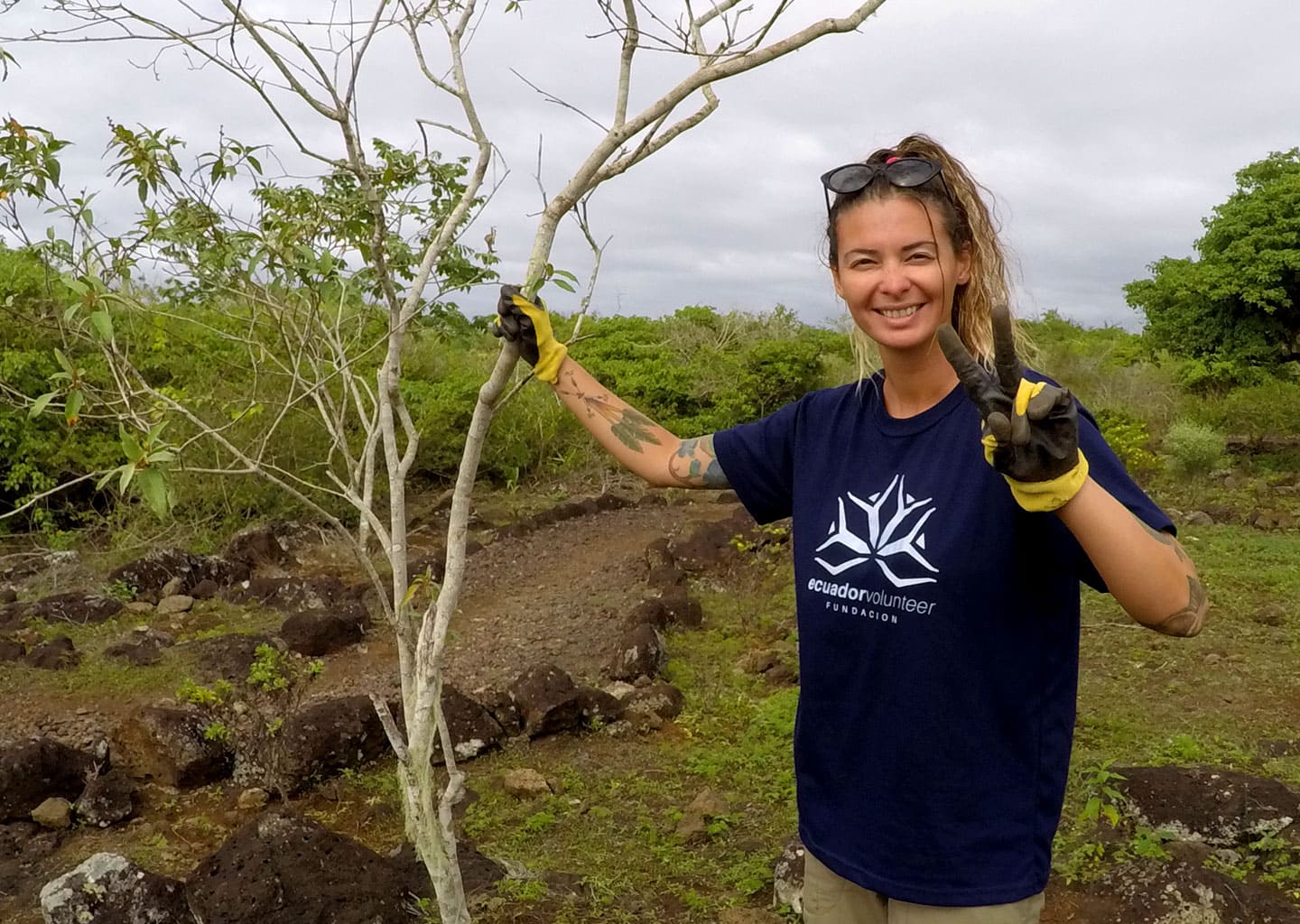 Volunteer alongside a matazarno tree enjoying her time into the conservation project.