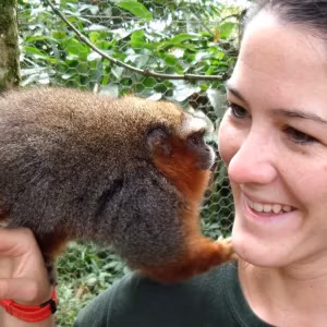 Teen Camp participant in the Amazon with a monkey during a species feeding activity.