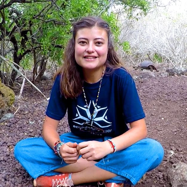 Portrait of Martina, former Teen Camp participant, sitting in Galapagos with a giant tortoise behind her. Her testimonial highlights personal growth and learning values.