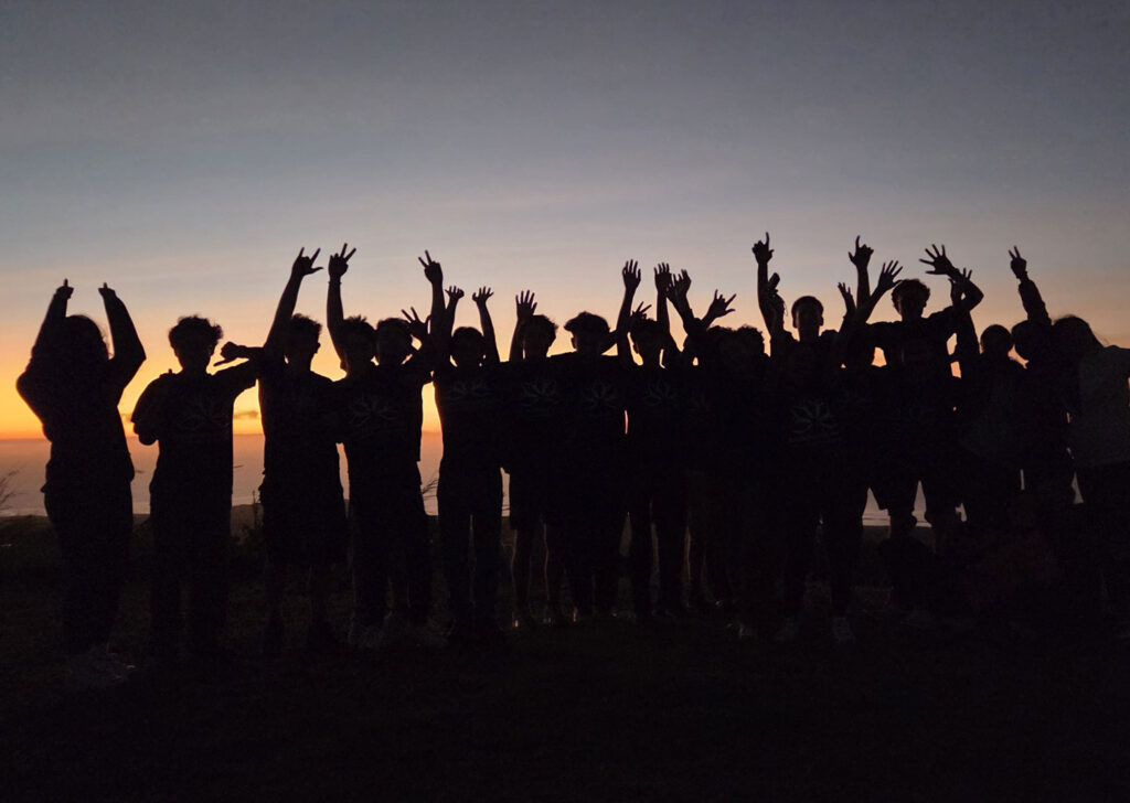 Teen Camp participants watching the sunset by the sea.