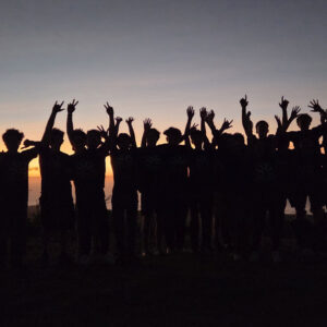 Teen Camp participants watching the sunset by the sea.