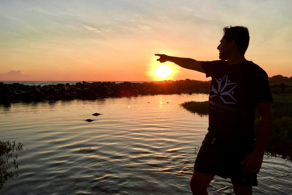 Teen Camp participant in the Galapagos watching the sunset by the sea.