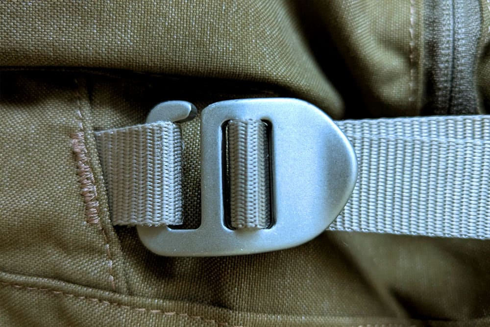 Close-up of a strap with a silver security buckle on a travel backpack. A symbol of safety and sturdy equipment for volunteer programs in Ecuador.