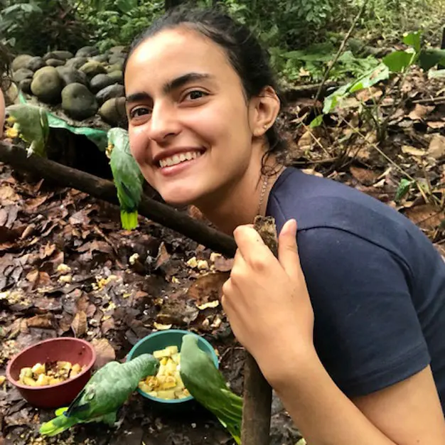 Teen participant feeding rescued parrots during Amazon Teen Camp Ecuador wildlife conservation volunteer experience