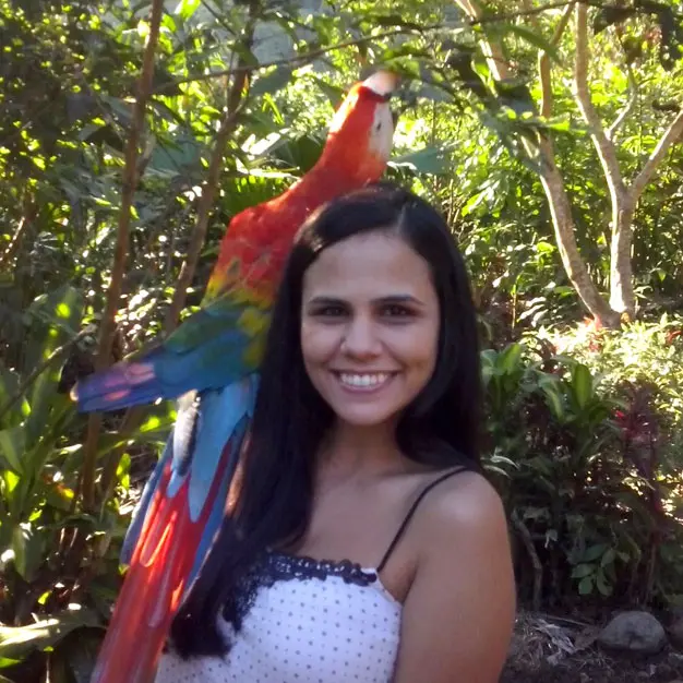 Teen participant smiling with a colorful macaw during Amazon Teen Camp Ecuador wildlife conservation experience