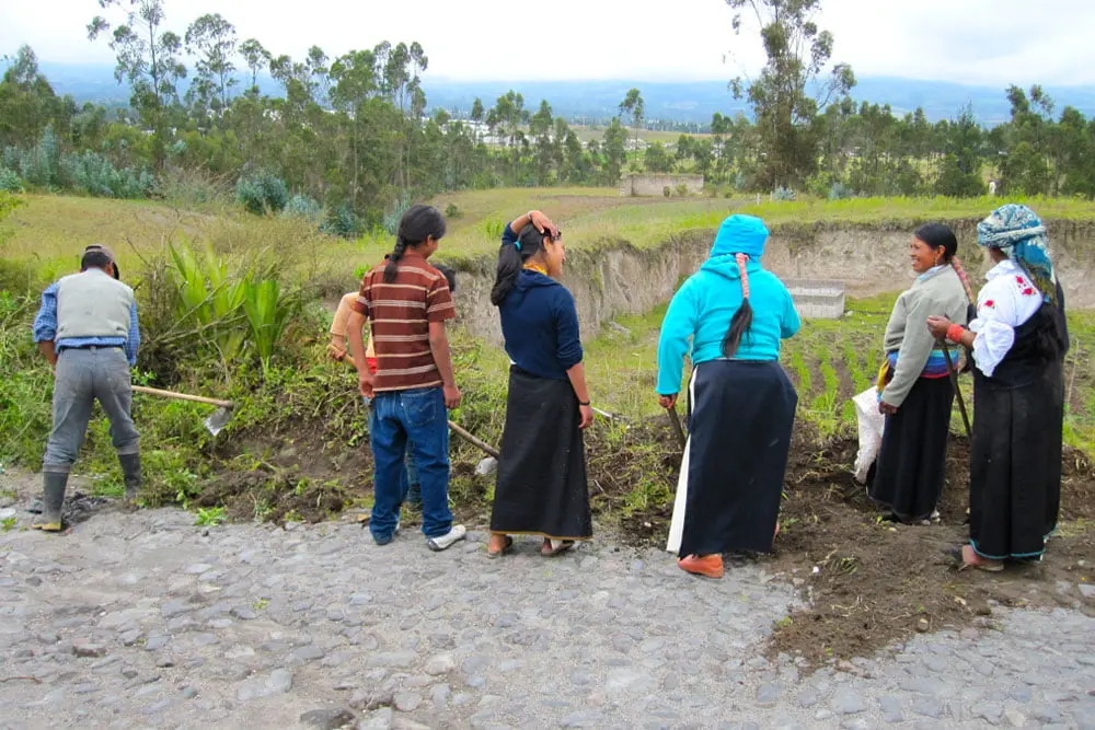 Indigenous community members participating in a traditional minga activity in the Ecuadorian Andes
